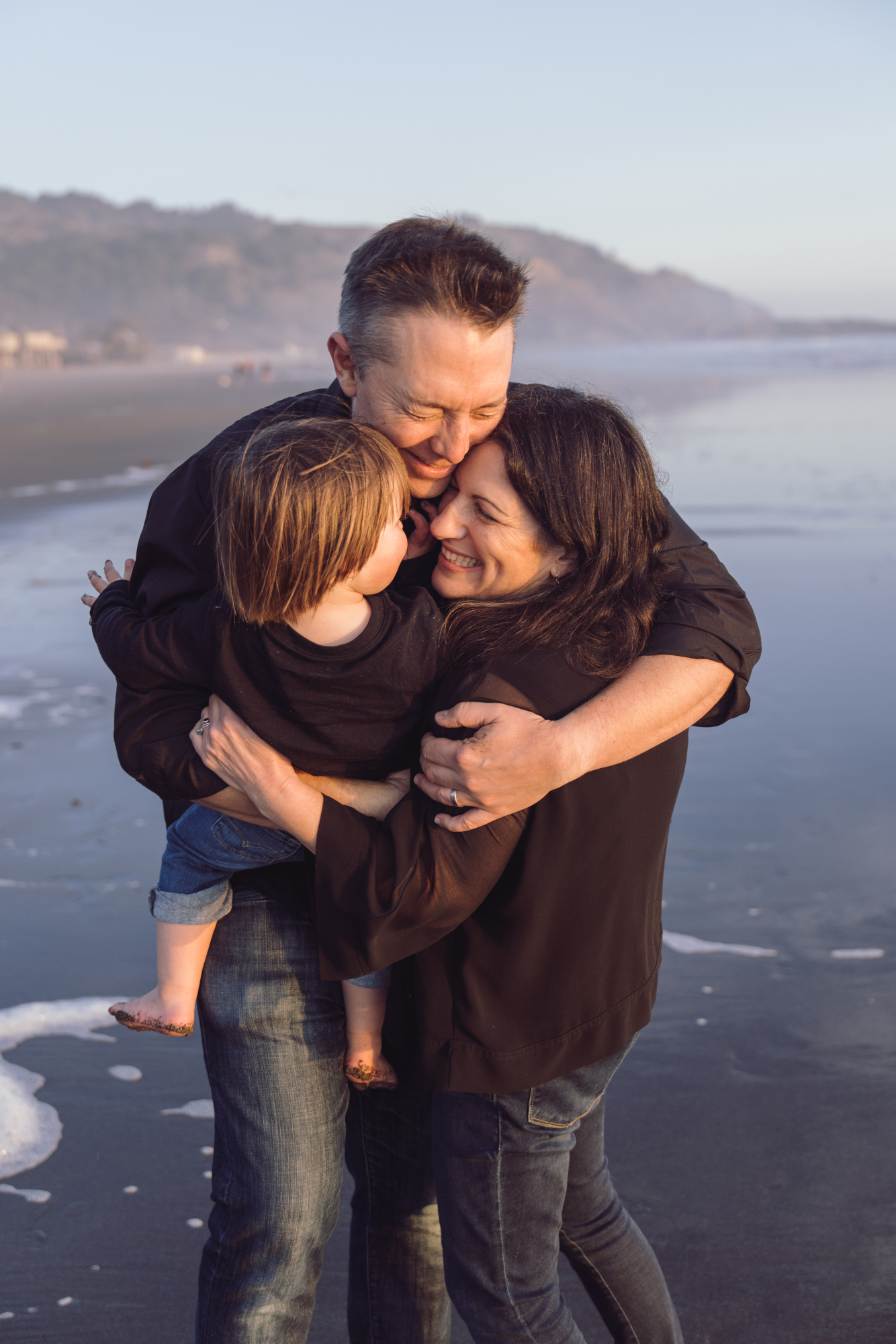Family embracing in the surf on Fenwick Island